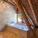 Elegant bathroom interior featuring a bathtub and rustic wooden ceiling design.