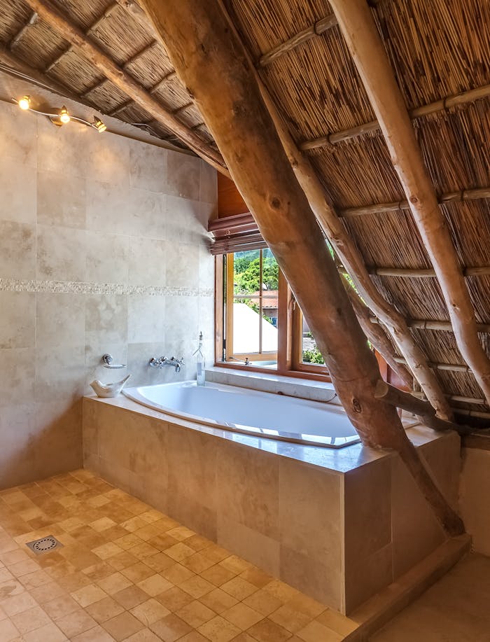 Elegant bathroom interior featuring a bathtub and rustic wooden ceiling design.